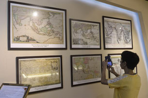 Một bạn trẻ dùng điện thoại chụp lại những tấm bản đồ cổ tại một cuộc triển lãm về Hoàng Sa, Trường Sa tại Bảo tàng Quân đội, Hà Nội vào ngày 10/7/2013 AFP photo