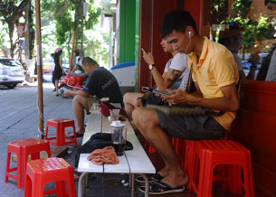 Truy cập internet bằng iPhone, Ipad tại những quán cà phê vỉa hè Hà Nội hôm 01/8/2013 AFP photo  